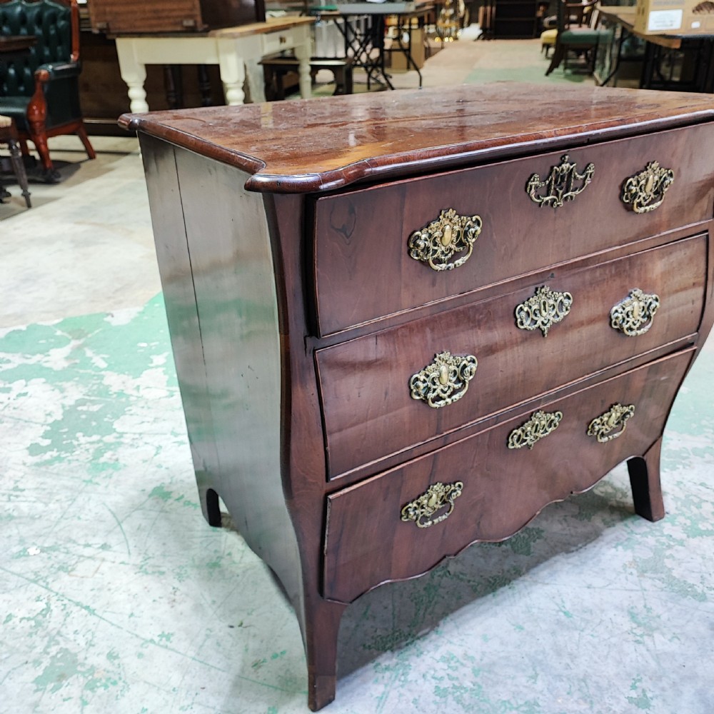 An eighteenth-century Dutch mahogany chest of drawers with a bombee front, three drawers, and cast brass handles. View II