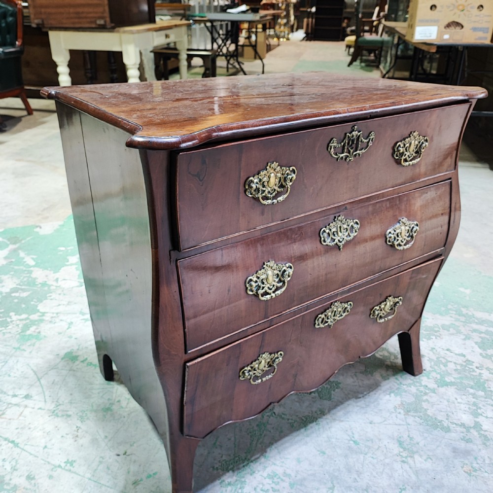 An eighteenth-century Dutch mahogany chest of drawers with a bombee front, three drawers, and cast brass handles. View III