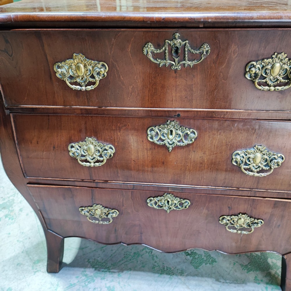An eighteenth-century Dutch mahogany chest of drawers with a bombee front, three drawers, and cast brass handles. View IV