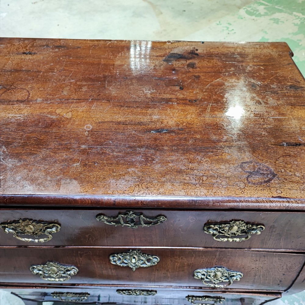 An eighteenth-century Dutch mahogany chest of drawers with a bombee front, three drawers, and cast brass handles. View V