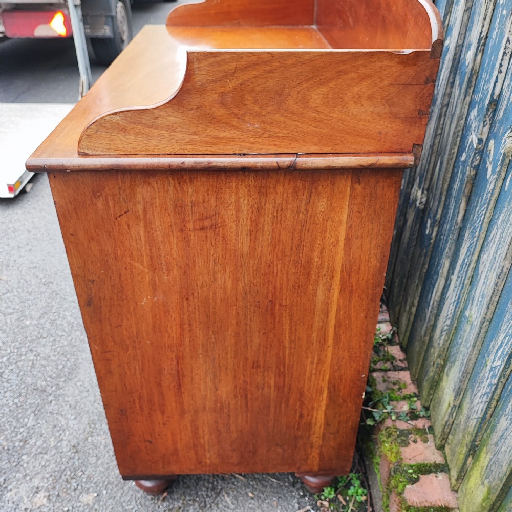 A small Victorian mahogany chest of drawers featuring a rear gallery upstand, two short over two long drawers, and round turned wooden handles. View II