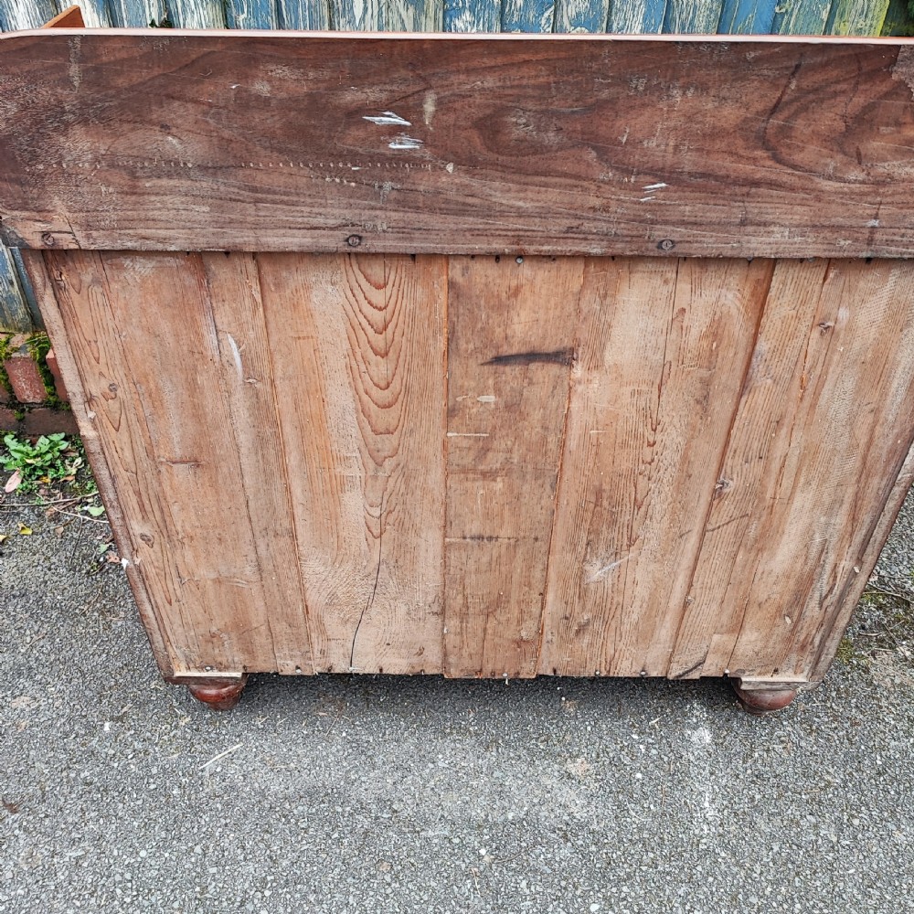 A small Victorian mahogany chest of drawers featuring a rear gallery upstand, two short over two long drawers, and round turned wooden handles. View VI