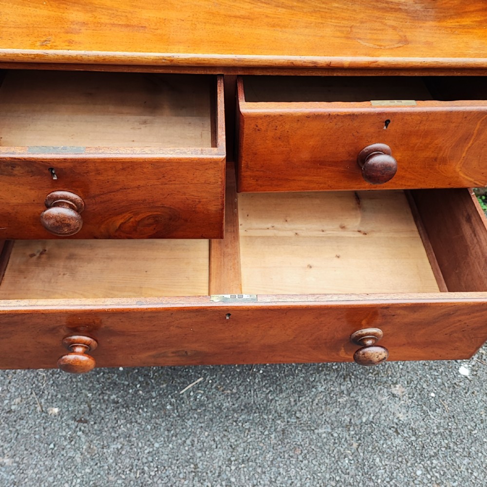 A small Victorian mahogany chest of drawers featuring a rear gallery upstand, two short over two long drawers, and round turned wooden handles. View VII
