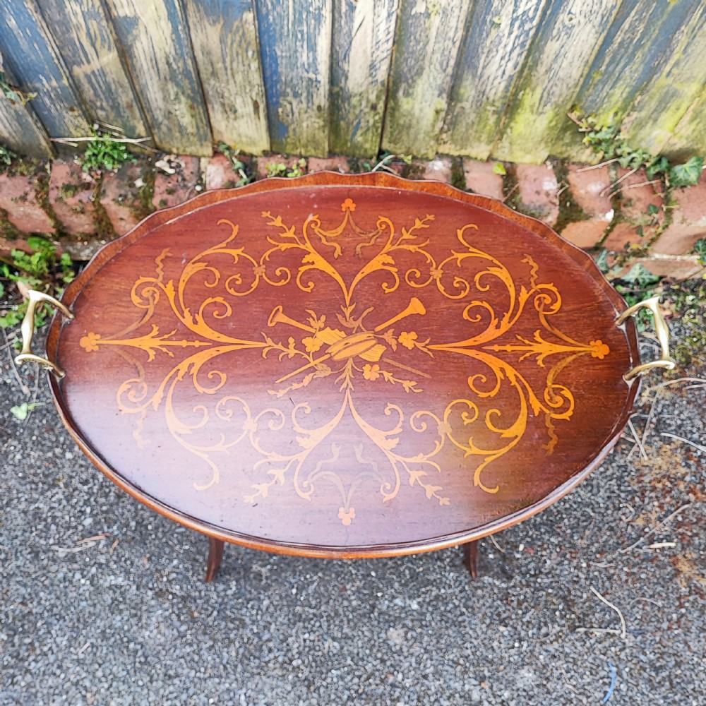 An oval mahogany side table featuring intricate floral marquetry inlay, a scalloped gallery rim, brass side handles, and slender curved legs. View II