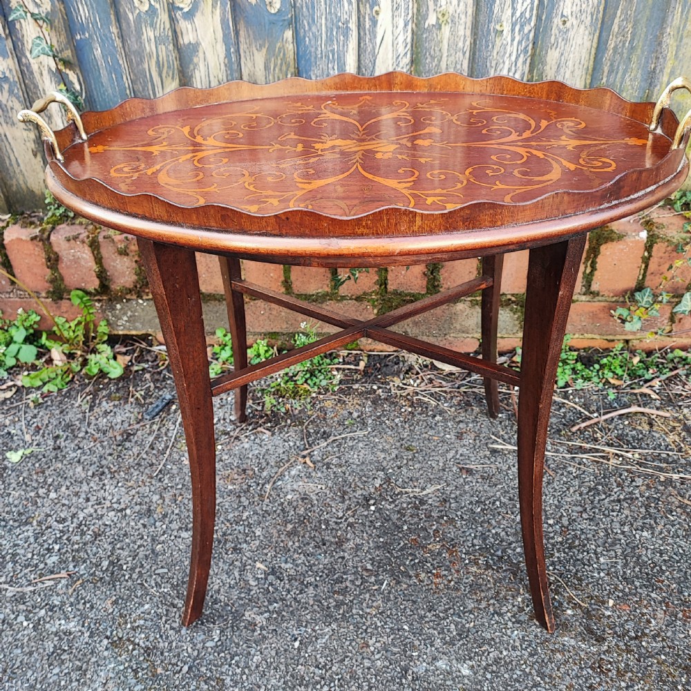 An oval mahogany side table featuring intricate floral marquetry inlay, a scalloped gallery rim, brass side handles, and slender curved legs. View V