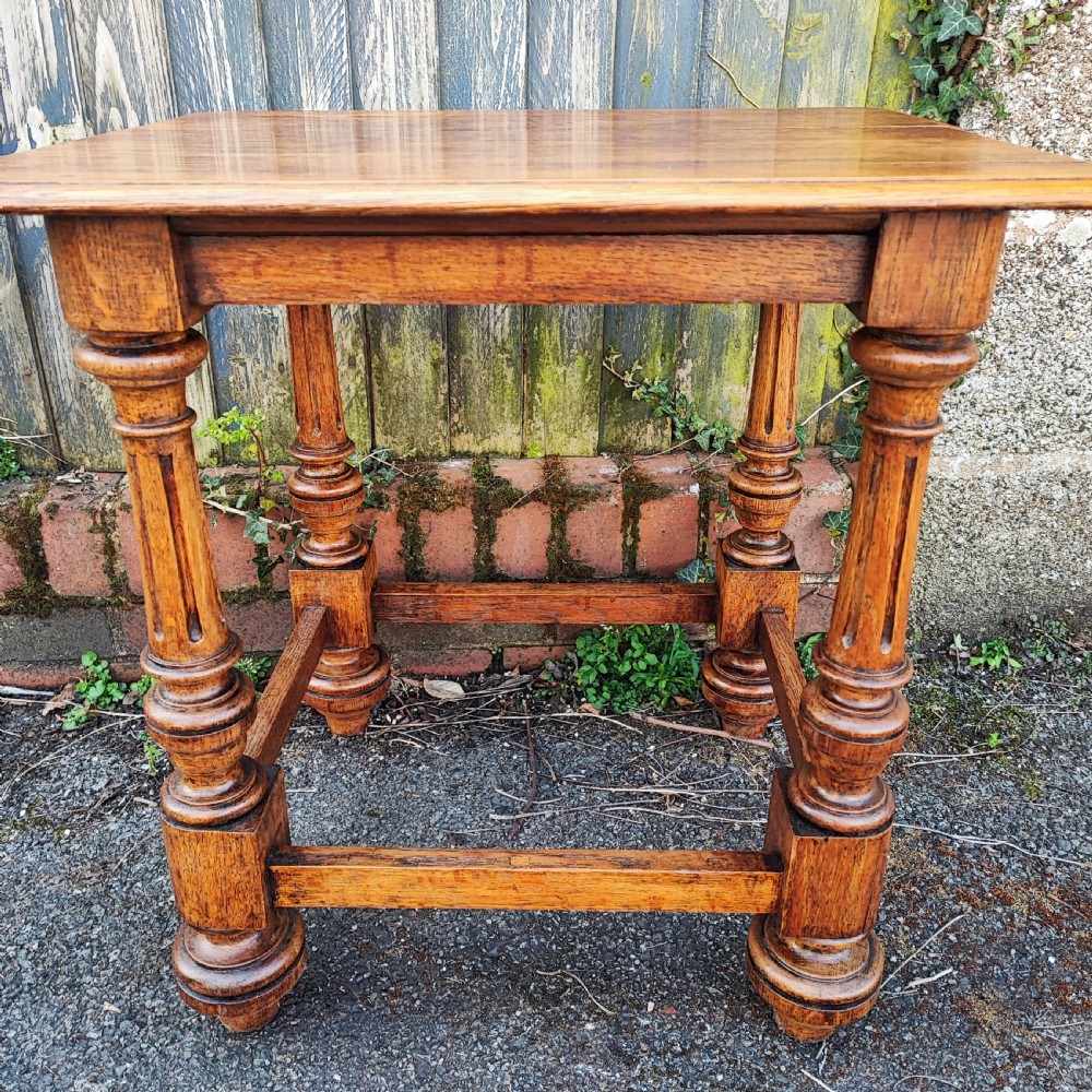 An antique oak low side table featuring fluted turned legs, square block joints, lower perimeter stretchers, and a rectangular top with moulded edges. View II