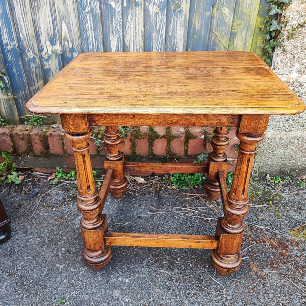 An antique oak low side table featuring fluted turned legs, square block joints, lower perimeter stretchers, and a rectangular top with moulded edges. View IV
