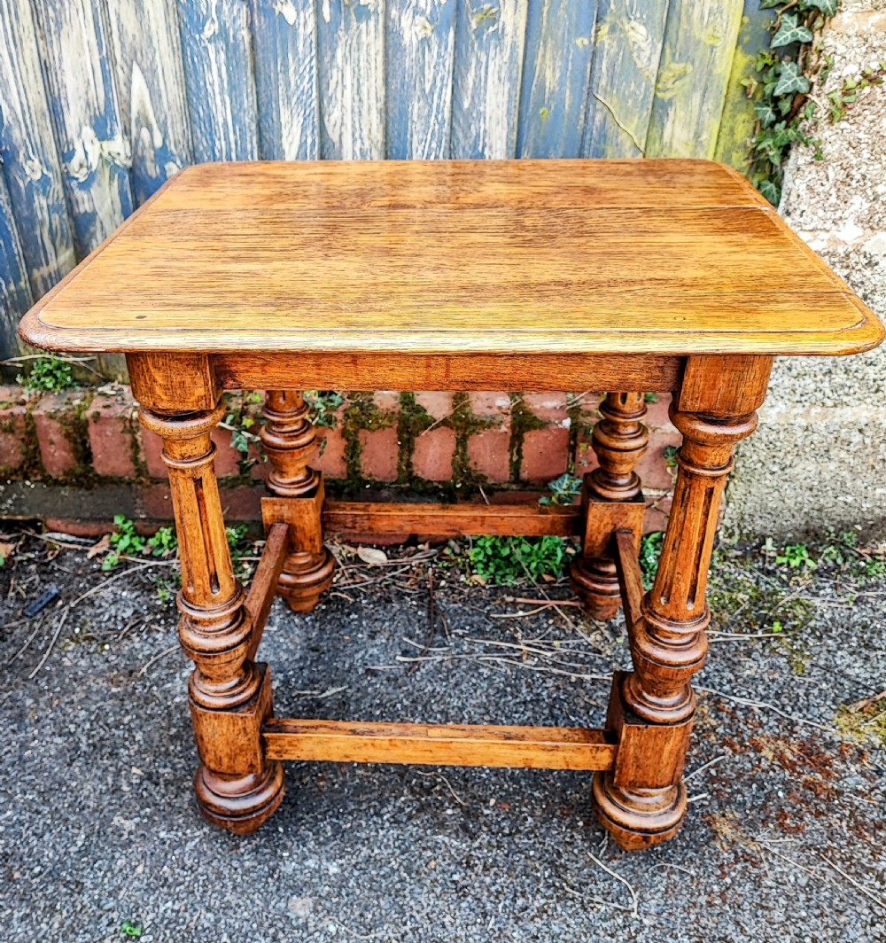 An antique oak low side table featuring fluted turned legs, square block joints, lower perimeter stretchers, and a rectangular top with moulded edges. View V