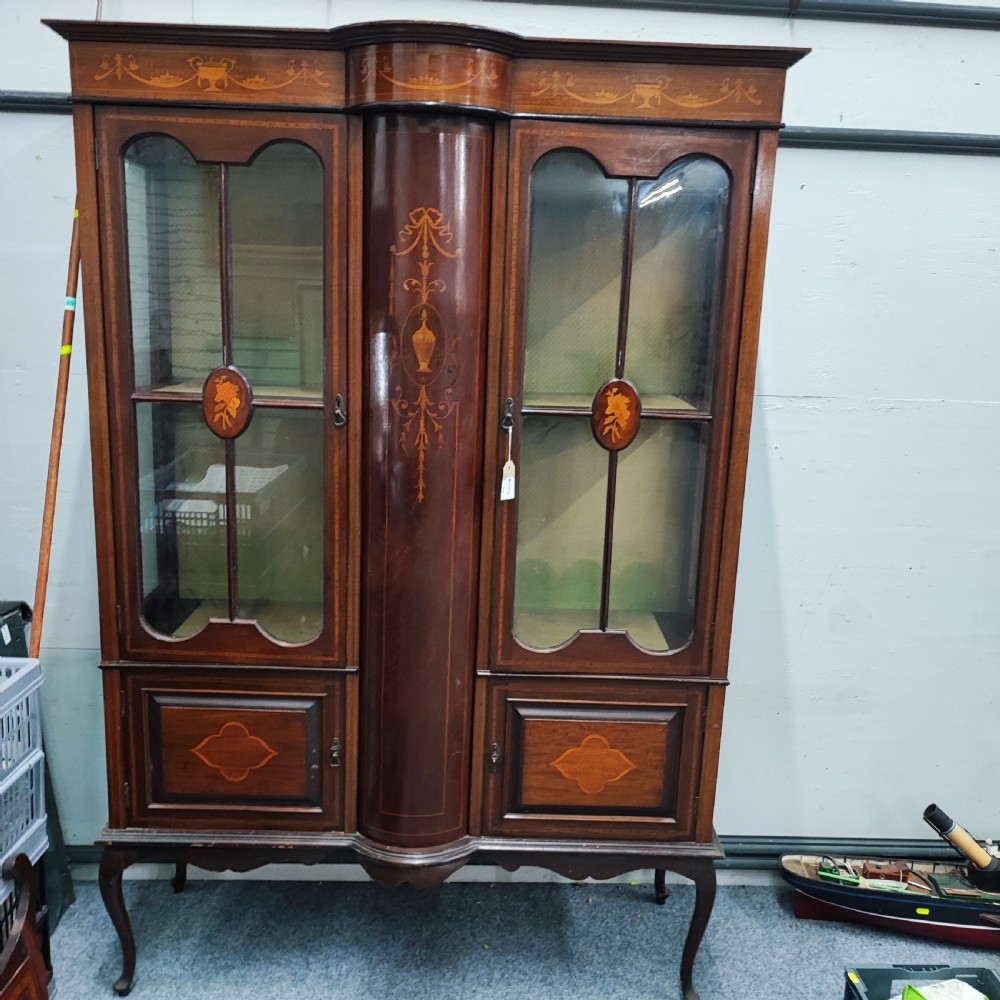 An Edwardian mahogany display cabinet featuring satinwood inlay, glazed doors with central floral motifs, and shaped legs. View III