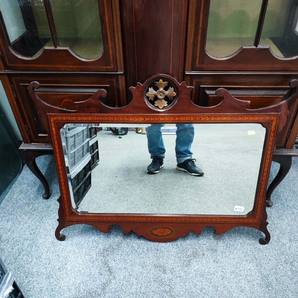 An Edwardian mahogany display cabinet featuring satinwood inlay, glazed doors with central floral motifs, and shaped legs. View VII
