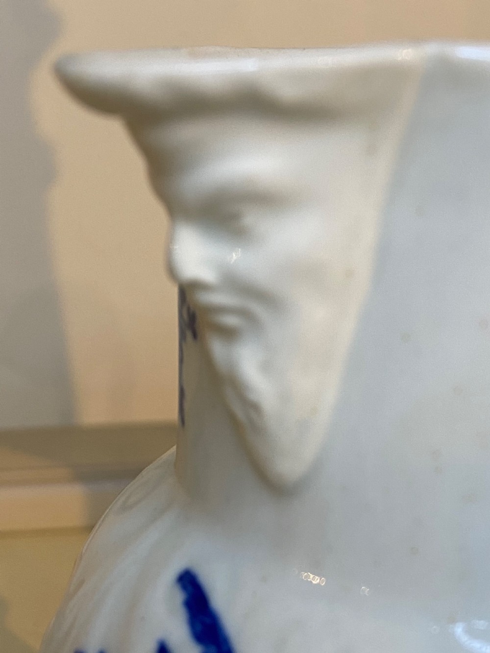 An antique Worcester blue and white porcelain jug featuring a moulded cabbage-leaf pattern, a bearded face mask spout, and bird decoration. View II