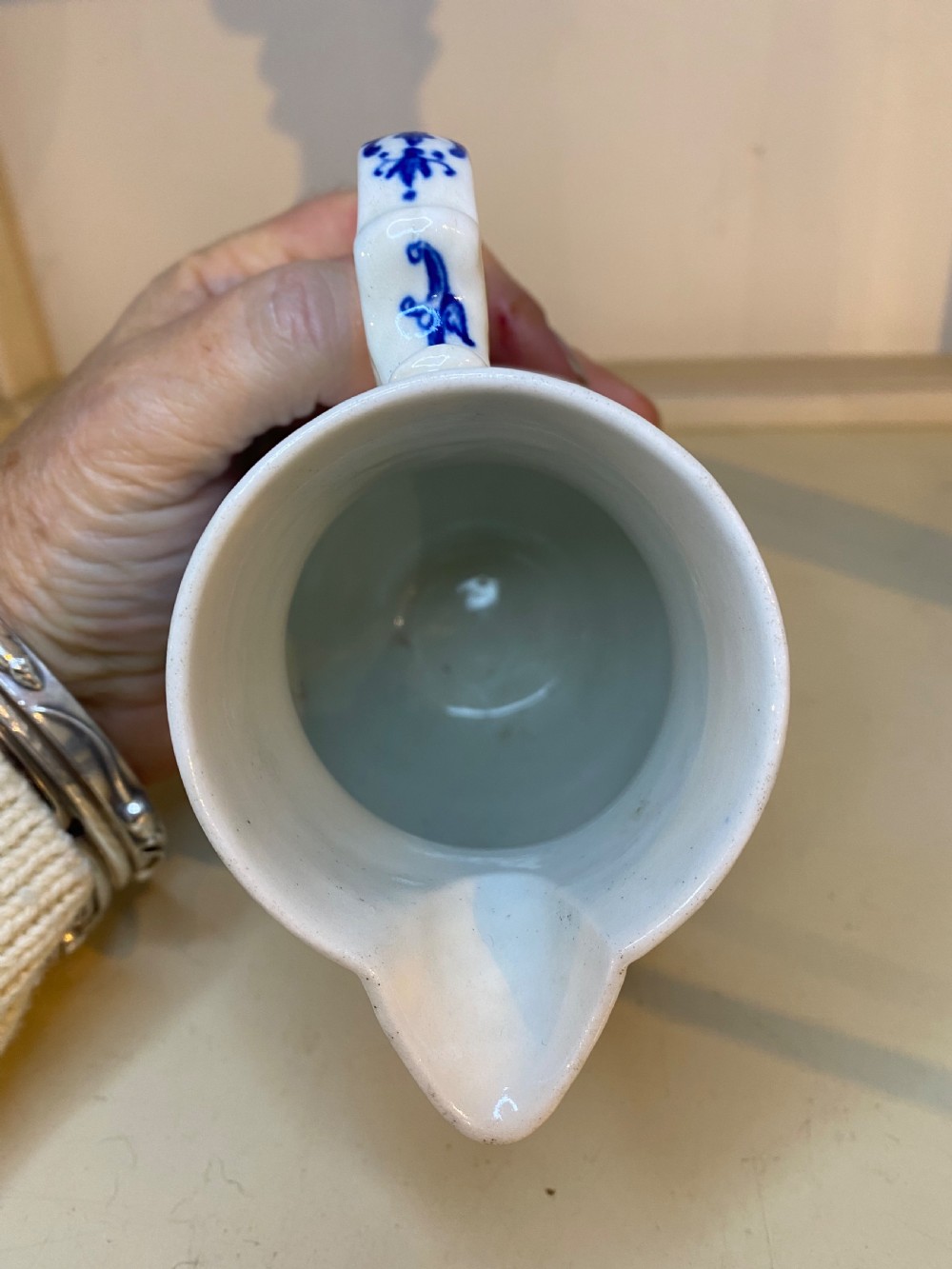 An antique Worcester blue and white porcelain jug featuring a moulded cabbage-leaf pattern, a bearded face mask spout, and bird decoration. View III