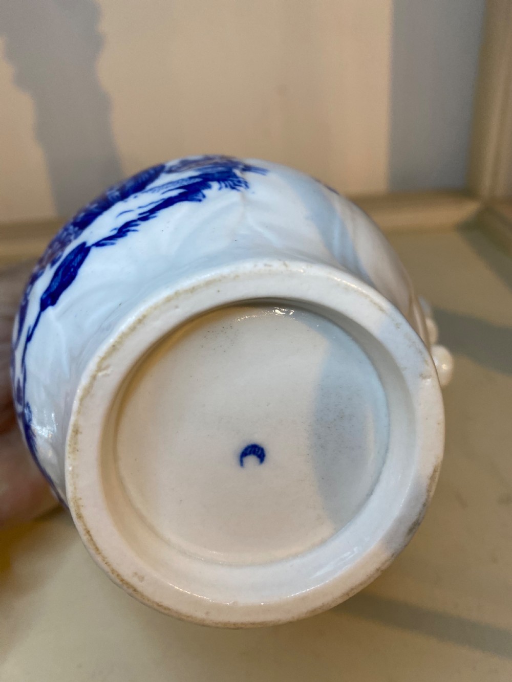 An antique Worcester blue and white porcelain jug featuring a moulded cabbage-leaf pattern, a bearded face mask spout, and bird decoration. View XII