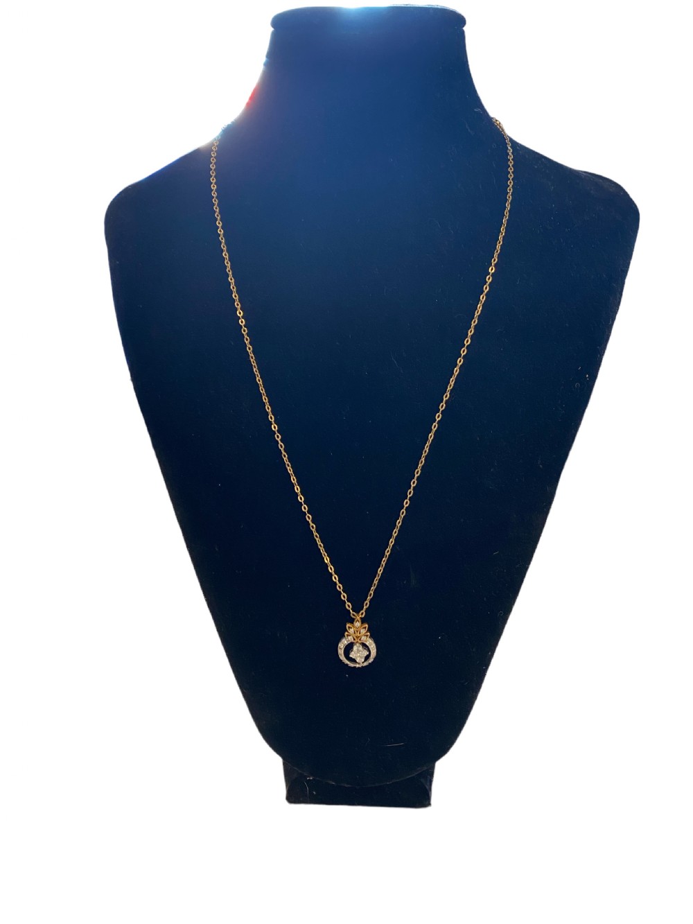 An Edwardian 18ct yellow gold chain supporting a delicate circular pendant set with brilliant diamonds.