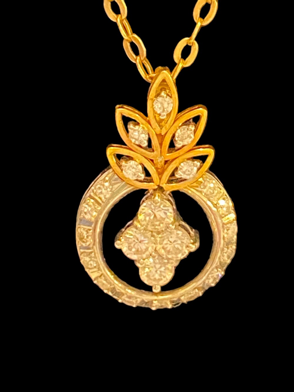 An Edwardian 18ct yellow gold chain supporting a delicate circular pendant set with brilliant diamonds. View II