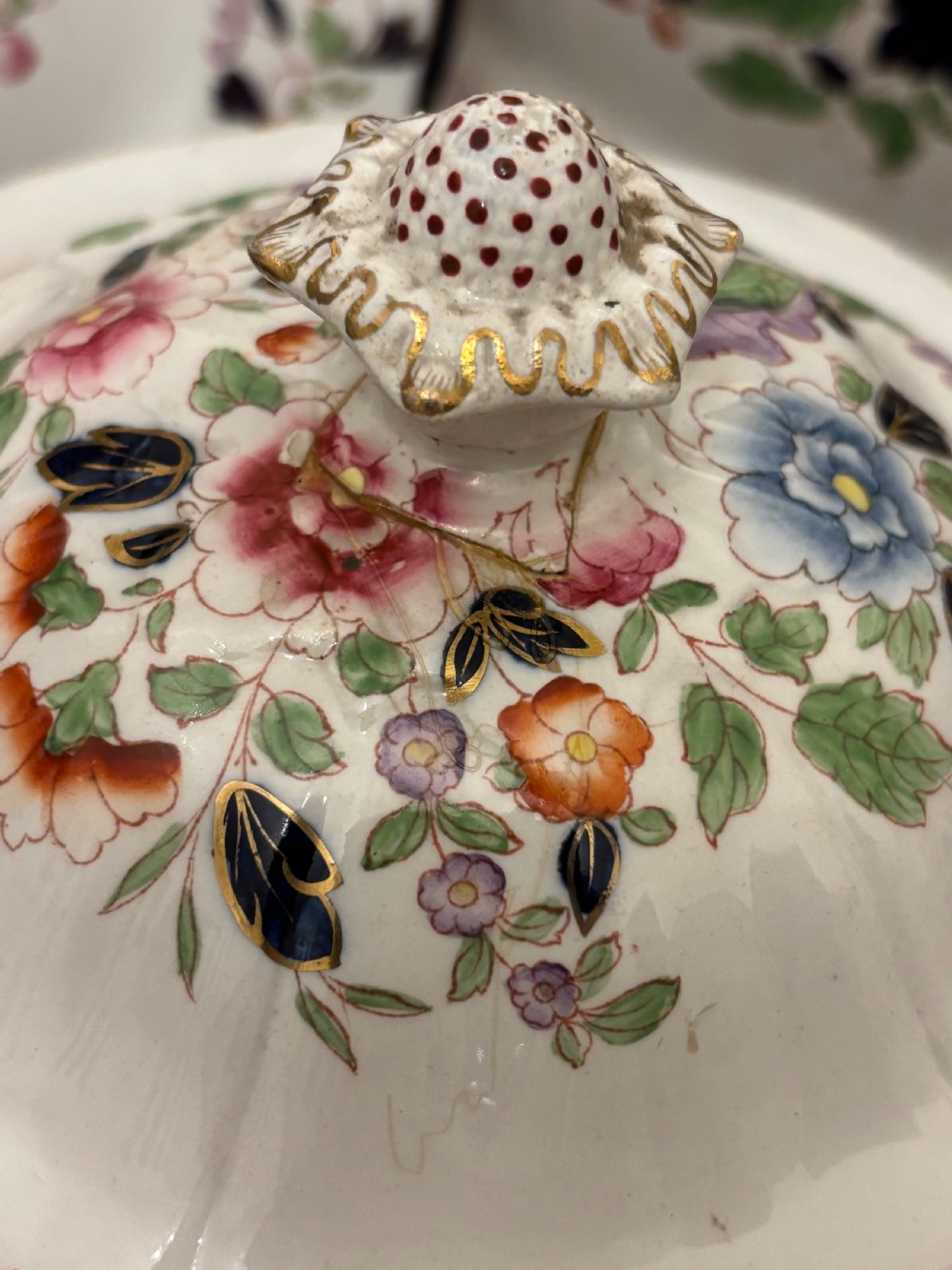 An extensive antique ceramic dinner service featuring floral transfers, matching tureens, bowls, and serving platters arranged together. View VI