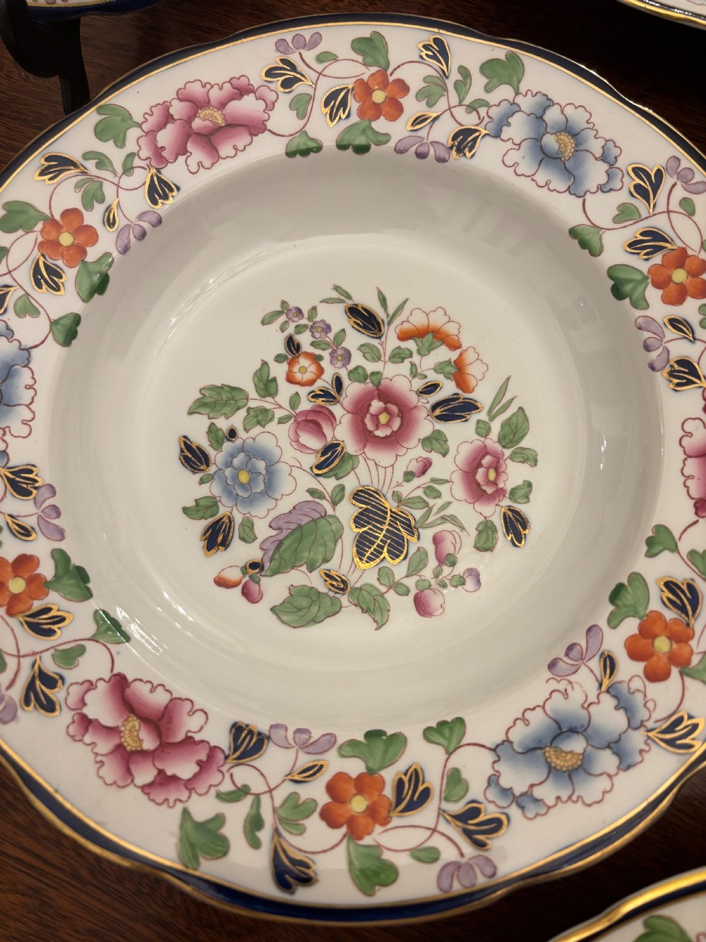 An extensive antique ceramic dinner service featuring floral transfers, matching tureens, bowls, and serving platters arranged together. View IX