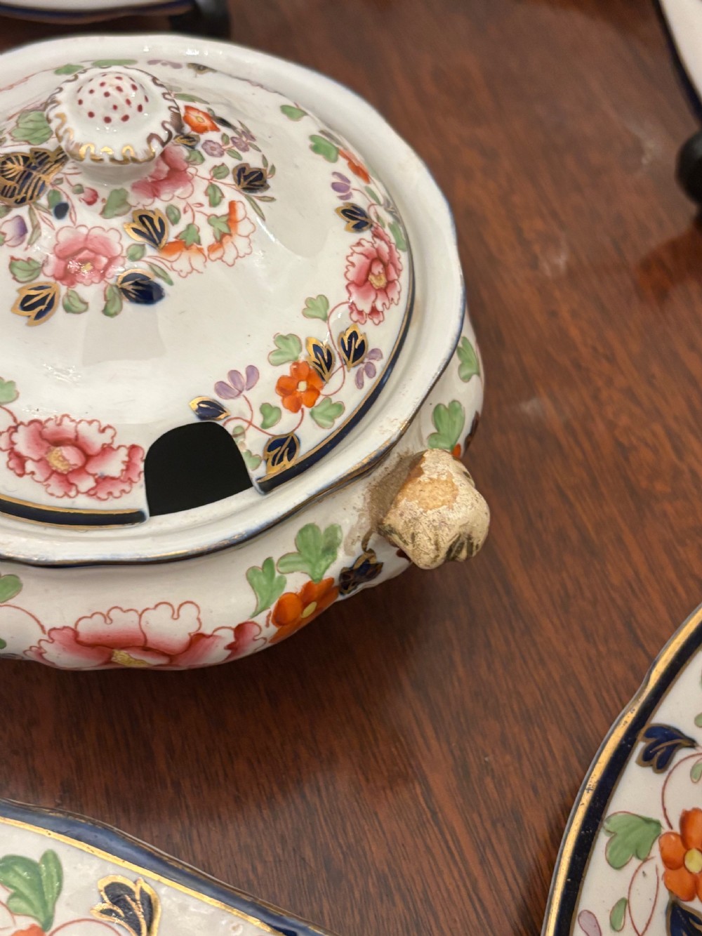 An extensive antique ceramic dinner service featuring floral transfers, matching tureens, bowls, and serving platters arranged together. View XIII