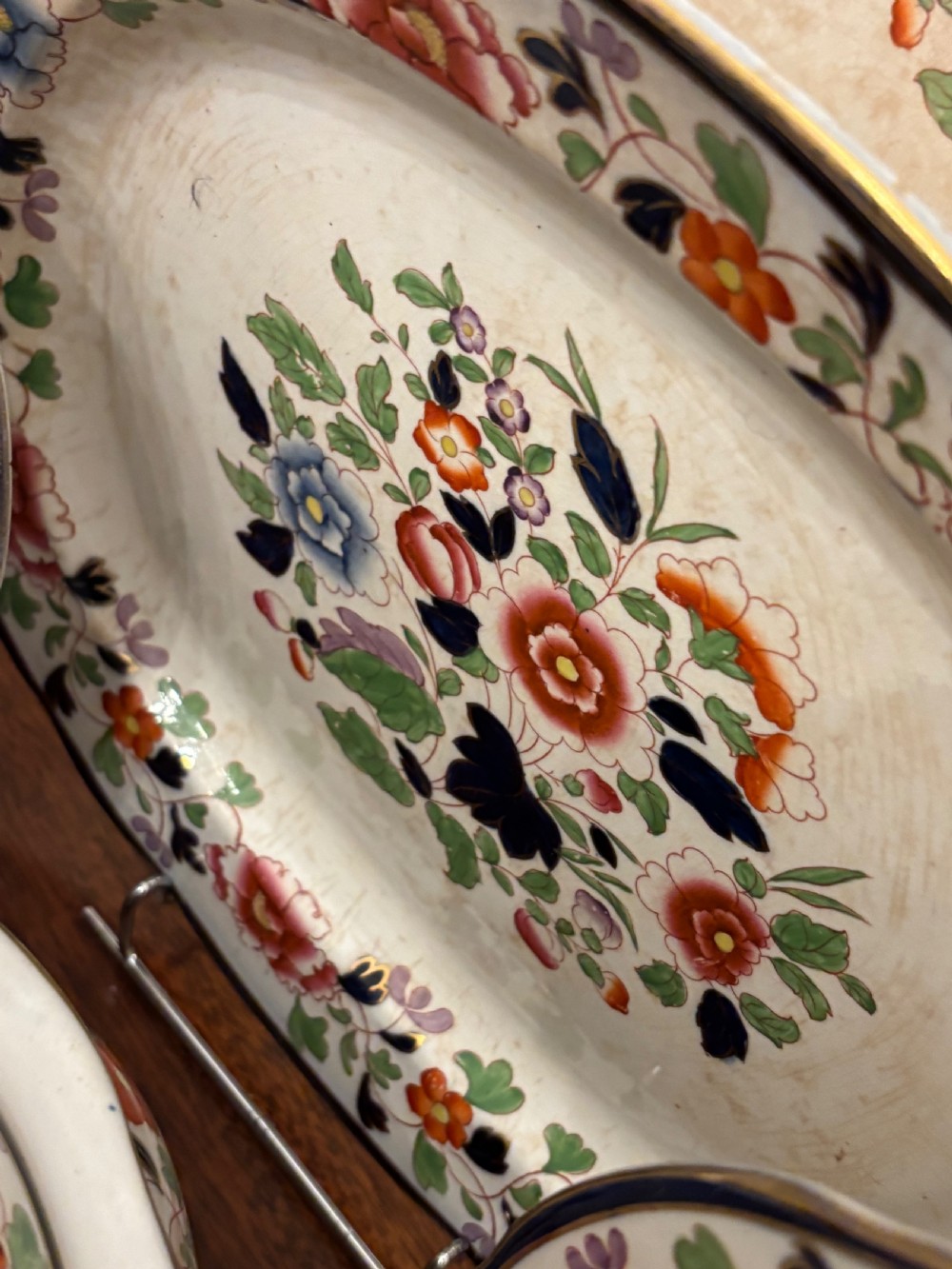 An extensive antique ceramic dinner service featuring floral transfers, matching tureens, bowls, and serving platters arranged together. View XIV