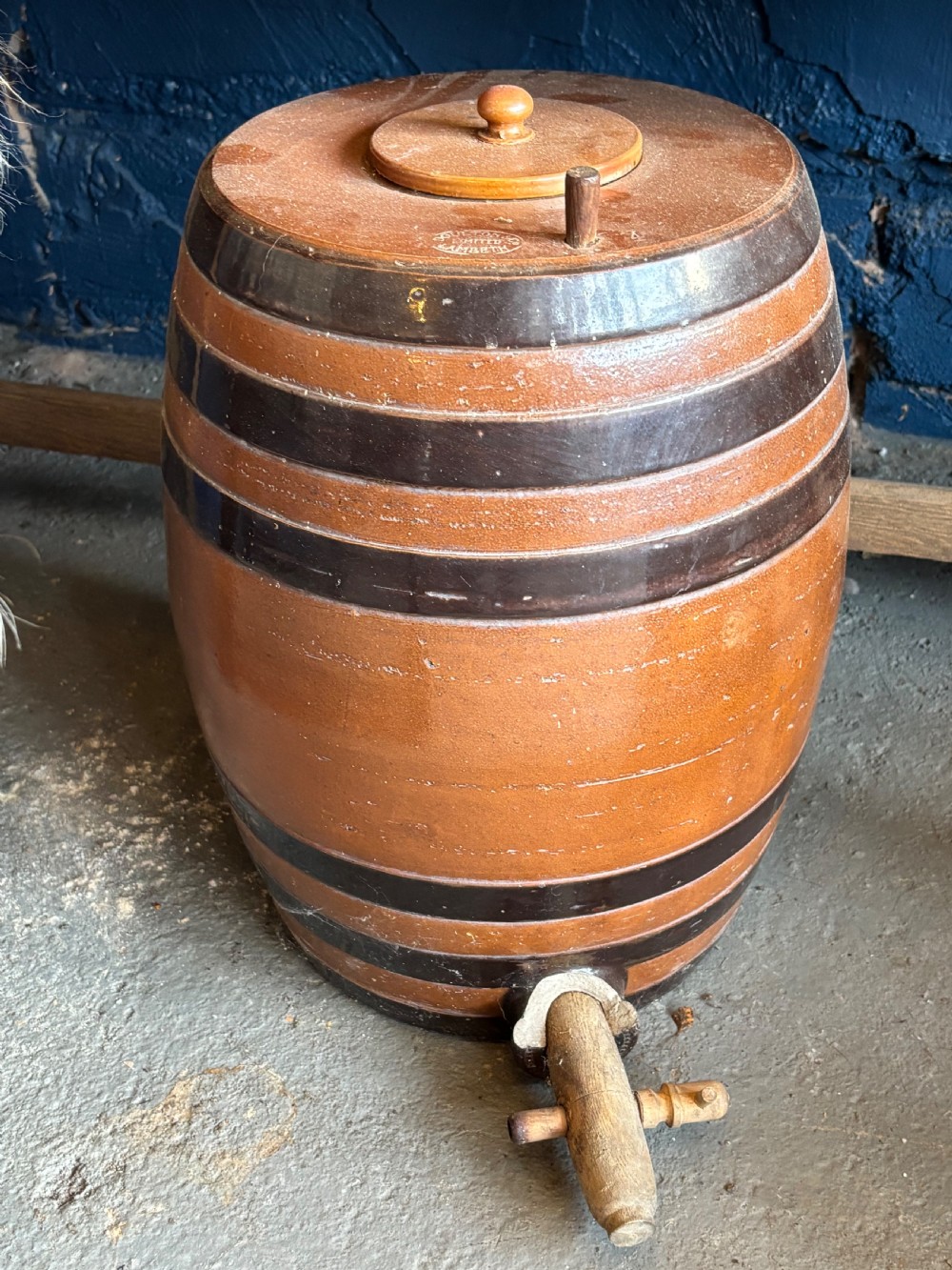 A Victorian Doulton Lambeth salt-glazed stoneware spirit cask featuring dark brown painted bands, a fitted wooden lid, and a wooden spigot tap at the base.