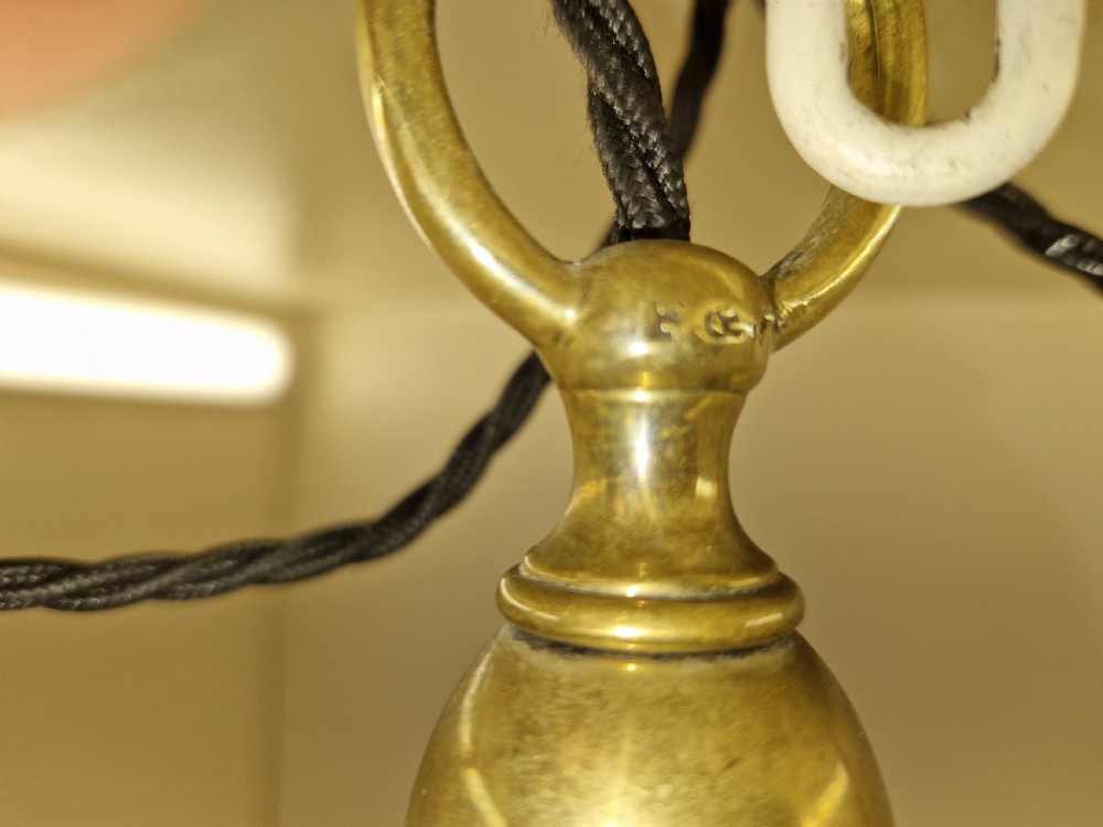 An Edwardian brass ceiling light fitting featuring three chain-suspended stiletto glass shades surrounding a central prismatic glass bowl. View X