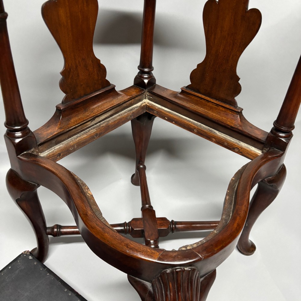 An 18th-century George III dark mahogany corner chair featuring a curved top rail, twin shaped splats, a dark leather seat, turned stretchers, and a front cabriole leg carved with a shell motif. View XI