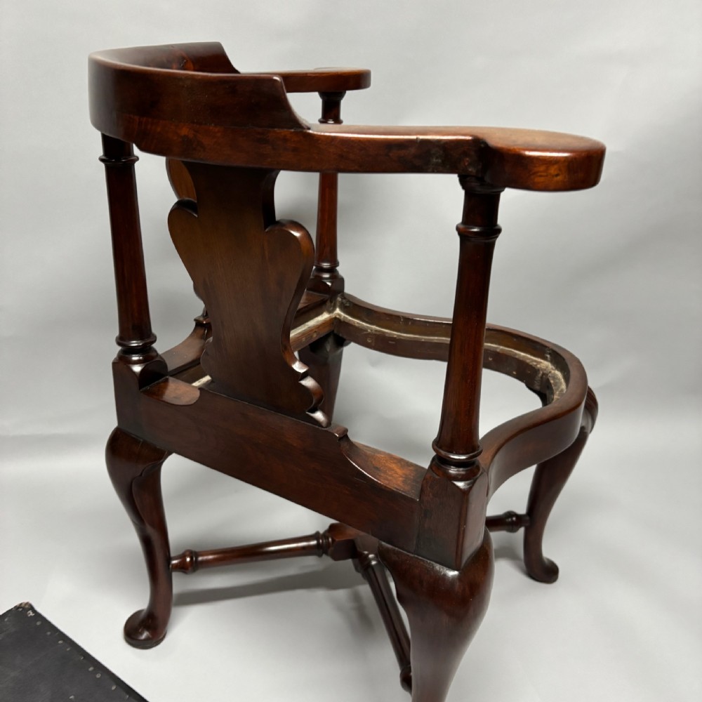 An 18th-century George III dark mahogany corner chair featuring a curved top rail, twin shaped splats, a dark leather seat, turned stretchers, and a front cabriole leg carved with a shell motif. View XIII