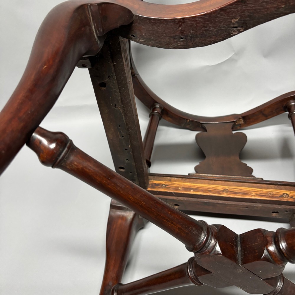 An 18th-century George III dark mahogany corner chair featuring a curved top rail, twin shaped splats, a dark leather seat, turned stretchers, and a front cabriole leg carved with a shell motif. View XIV