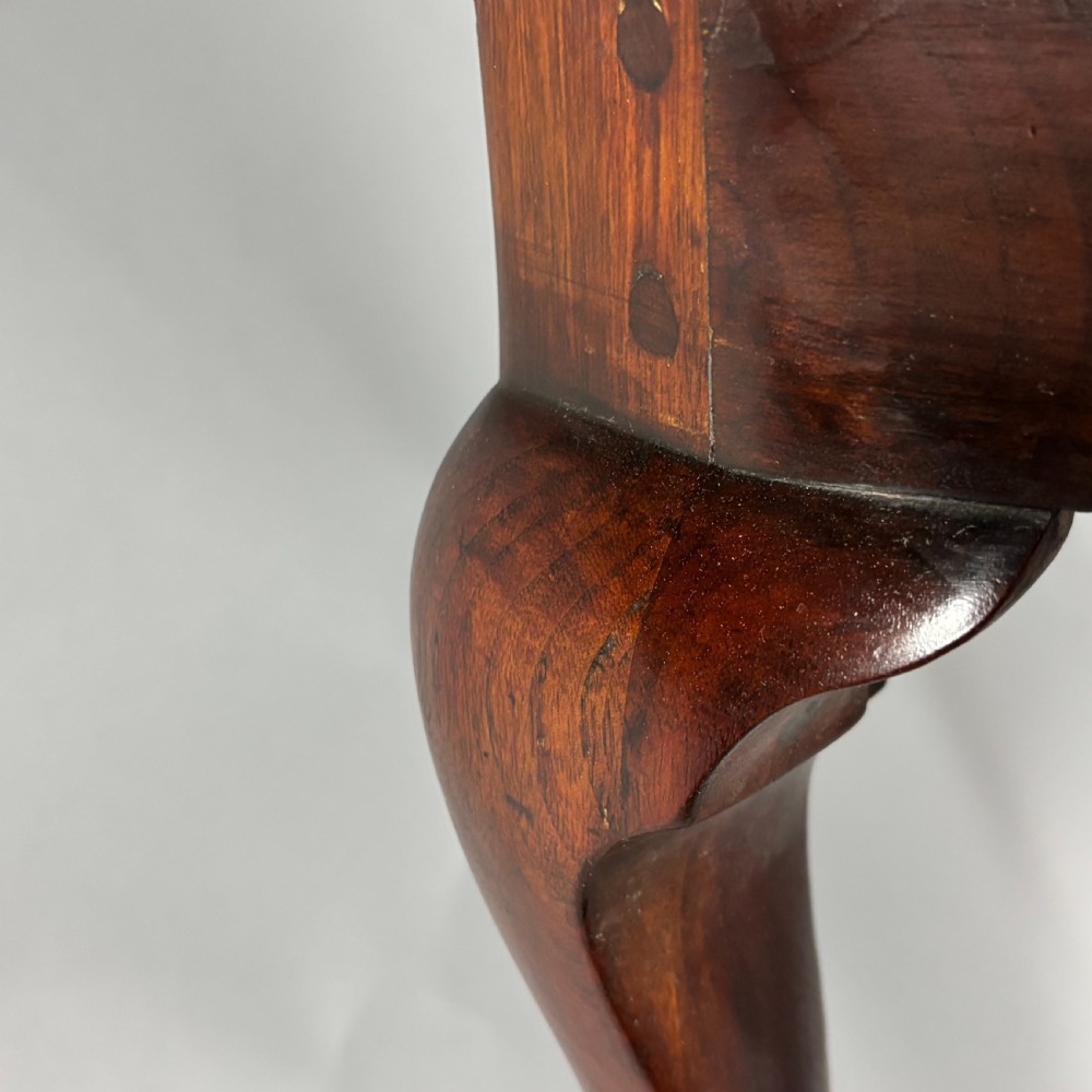 An 18th-century George III dark mahogany corner chair featuring a curved top rail, twin shaped splats, a dark leather seat, turned stretchers, and a front cabriole leg carved with a shell motif. View XIX