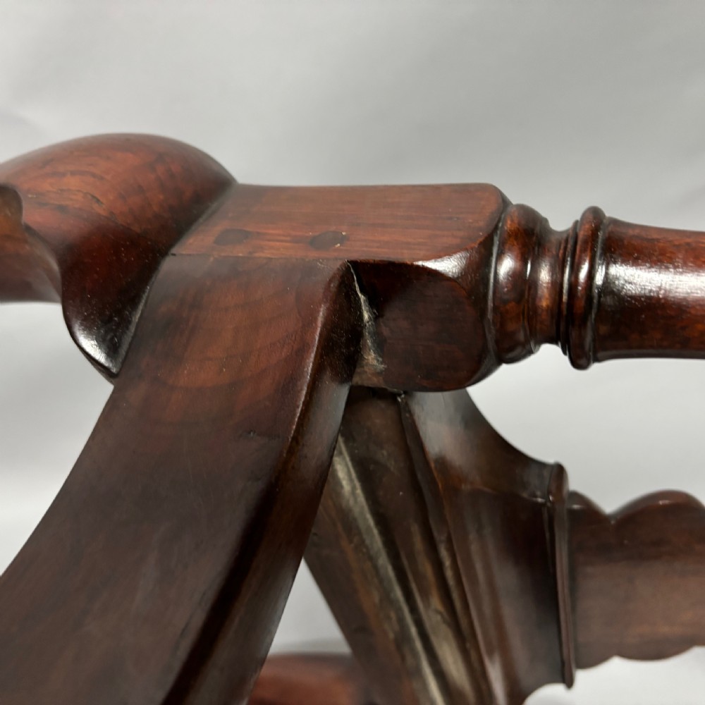 An 18th-century George III dark mahogany corner chair featuring a curved top rail, twin shaped splats, a dark leather seat, turned stretchers, and a front cabriole leg carved with a shell motif. View XX
