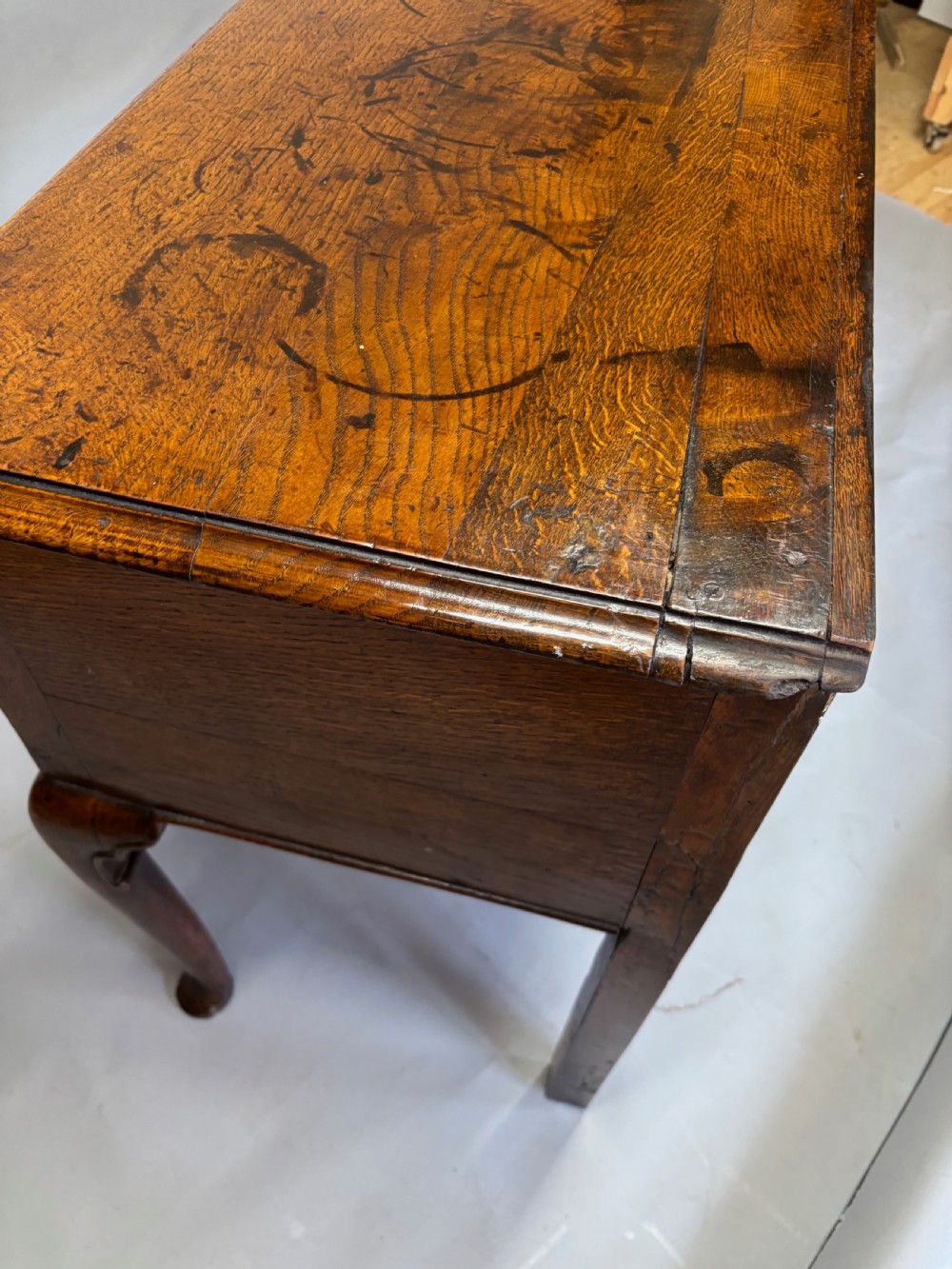 A George III period oak dresser base featuring three drawers with brass swan-neck handles and front cabriole legs. View II