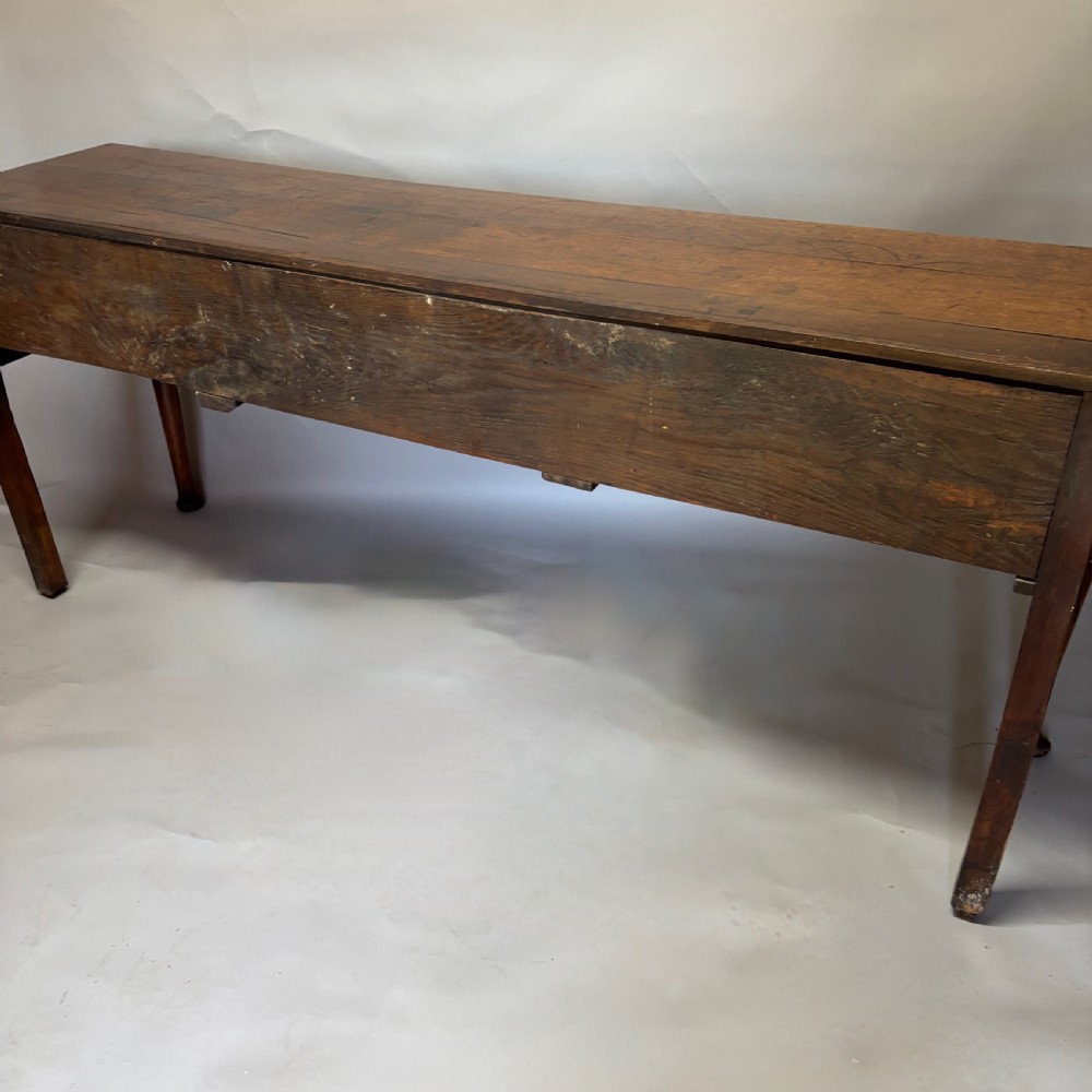 A George III period oak dresser base featuring three drawers with brass swan-neck handles and front cabriole legs. View IV