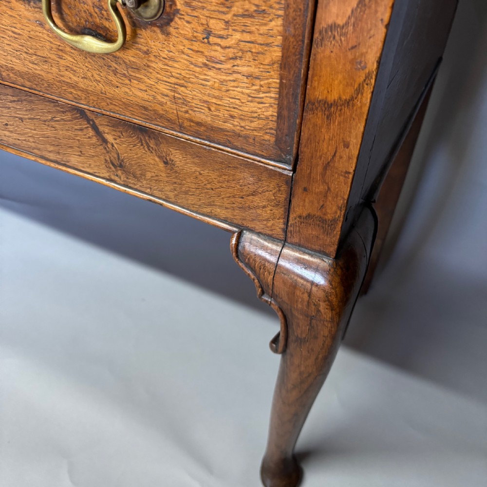A George III period oak dresser base featuring three drawers with brass swan-neck handles and front cabriole legs. View VIII