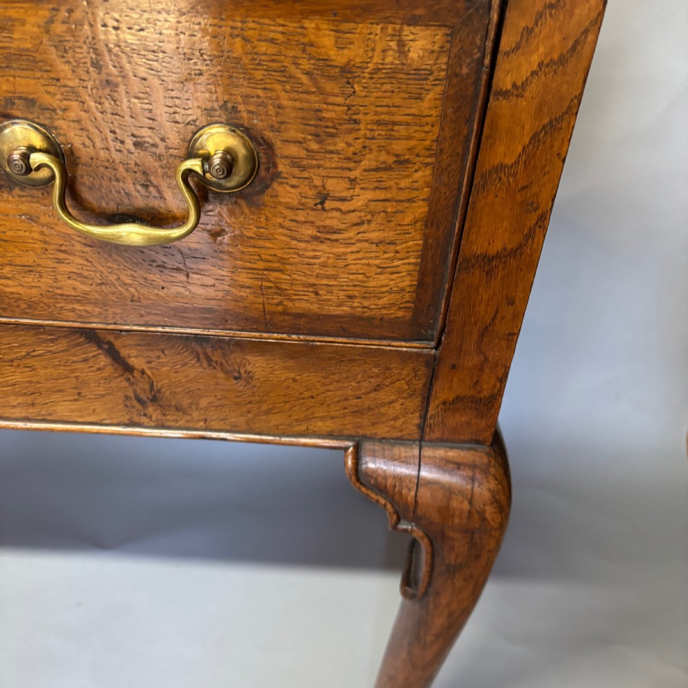 A George III period oak dresser base featuring three drawers with brass swan-neck handles and front cabriole legs. View XVIII