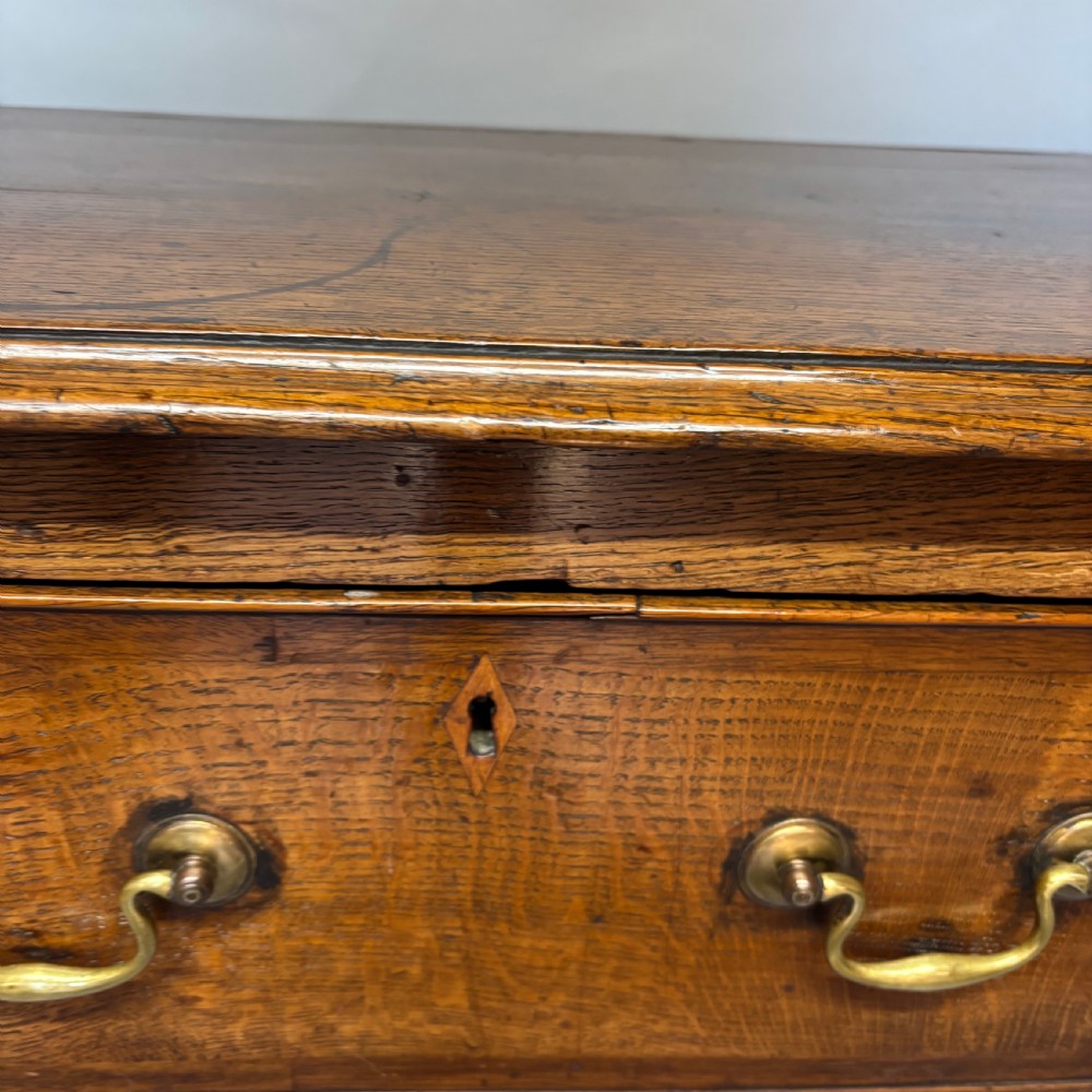 A George III period oak dresser base featuring three drawers with brass swan-neck handles and front cabriole legs. View XIX