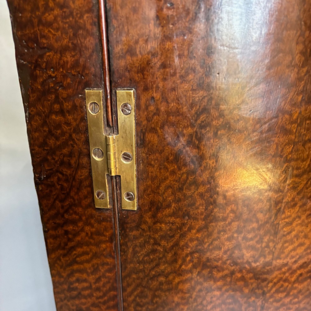 A Georgian bowfront mahogany corner cupboard featuring distinctive plum pudding grain, brass escutcheons, and visible brass H-hinges. View III