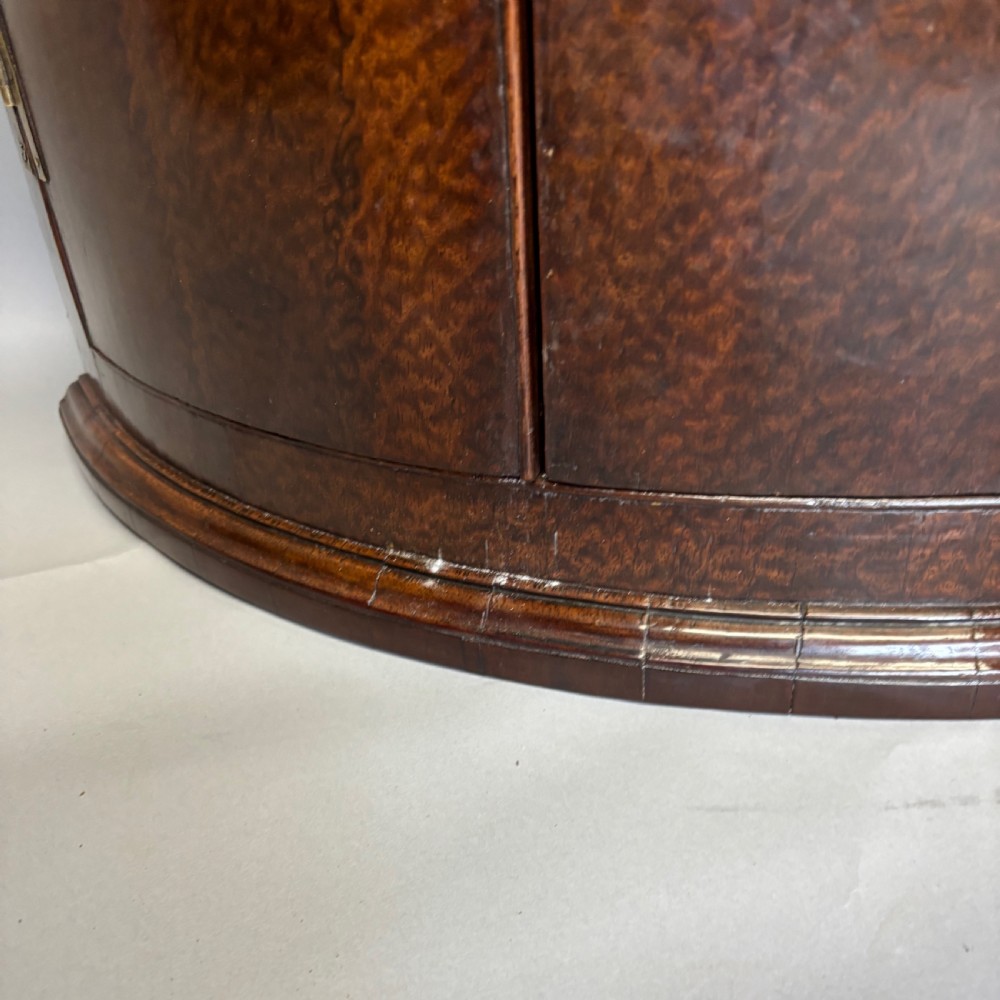 A Georgian bowfront mahogany corner cupboard featuring distinctive plum pudding grain, brass escutcheons, and visible brass H-hinges. View IX