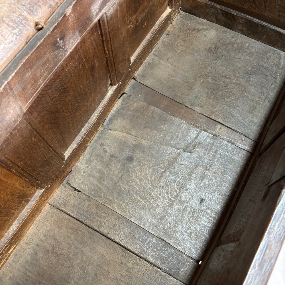 An eighteenth-century dark oak coffer with an arcaded carved top frieze, three lower plain panels, and a panelled hinged top. View VI