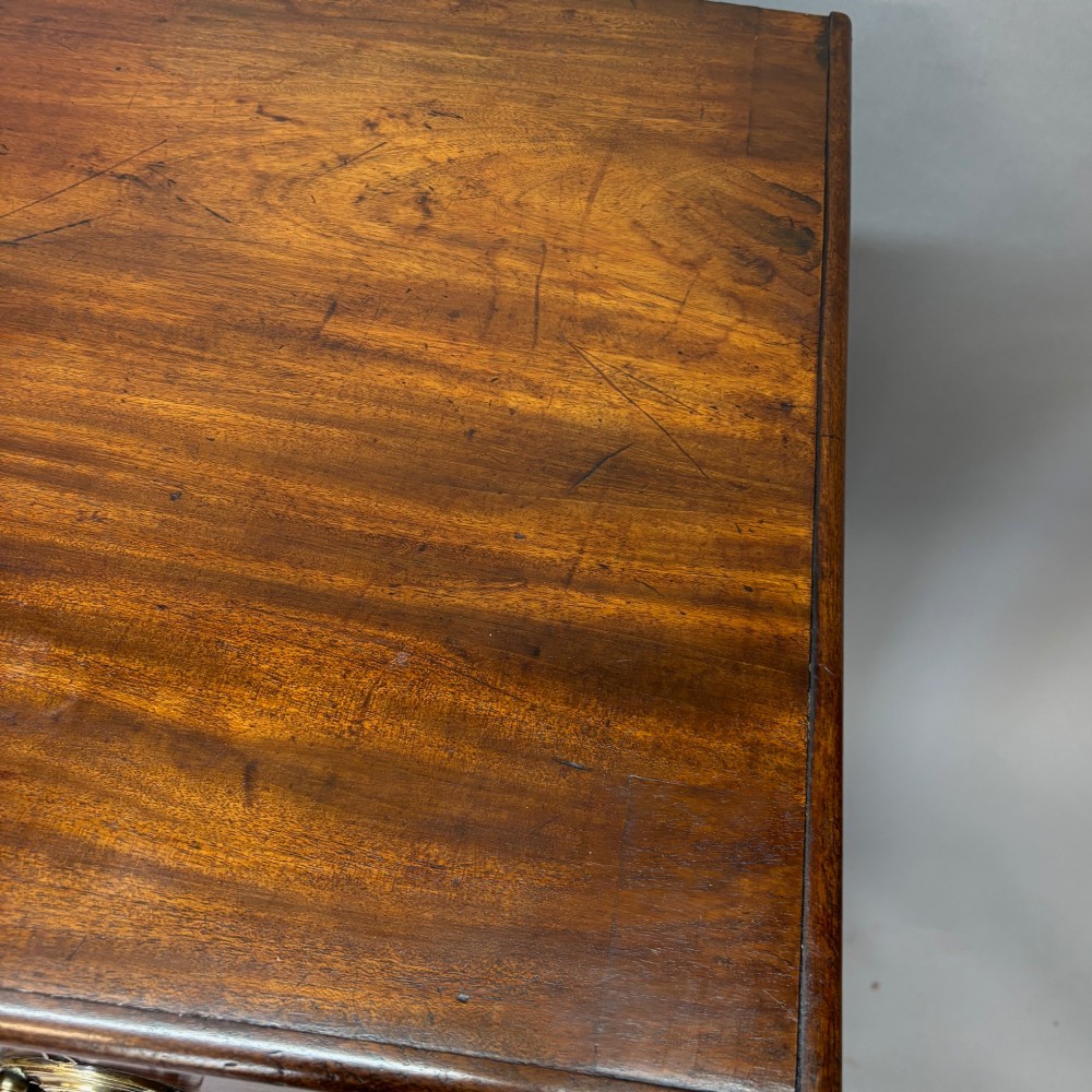 A Georgian George III mahogany chest of drawers featuring two short drawers above three long drawers with oval brass handles and bracket feet. View V