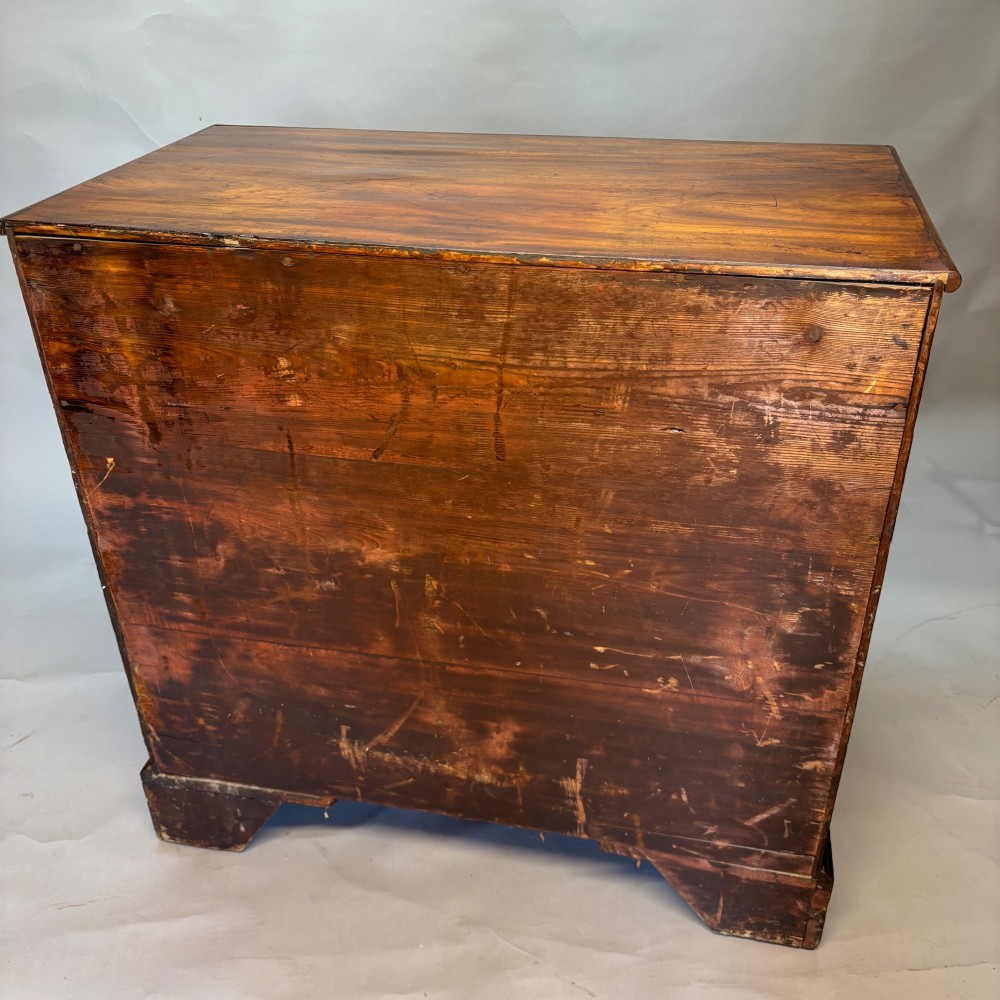 A Georgian George III mahogany chest of drawers featuring two short drawers above three long drawers with oval brass handles and bracket feet. View VI