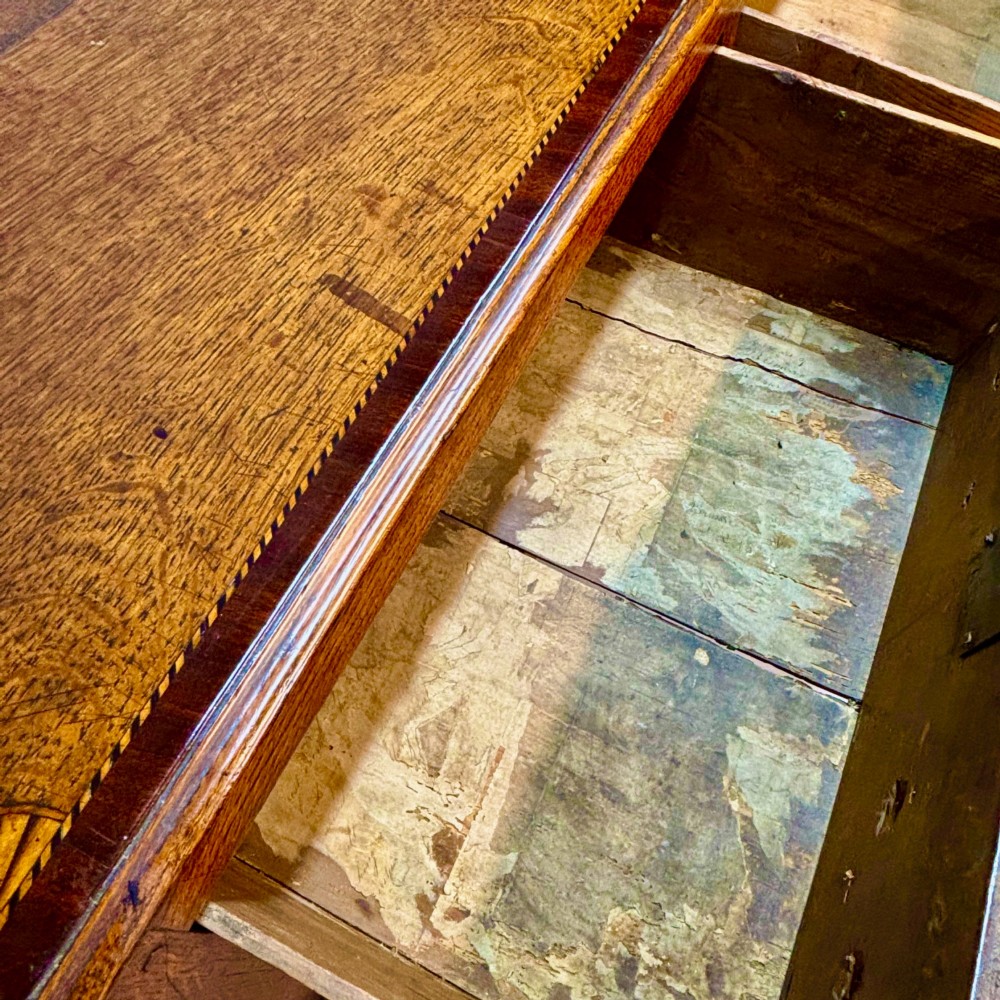 An eighteenth-century oak low dresser featuring three crossbanded drawers with brass swan-neck handles, elevated on four cabriole legs. View VIII