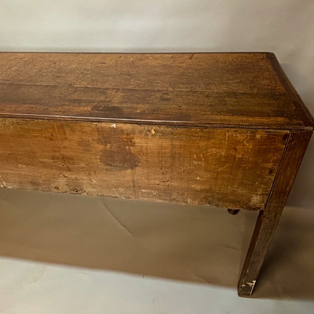An eighteenth-century oak low dresser featuring three crossbanded drawers with brass swan-neck handles, elevated on four cabriole legs. View XI