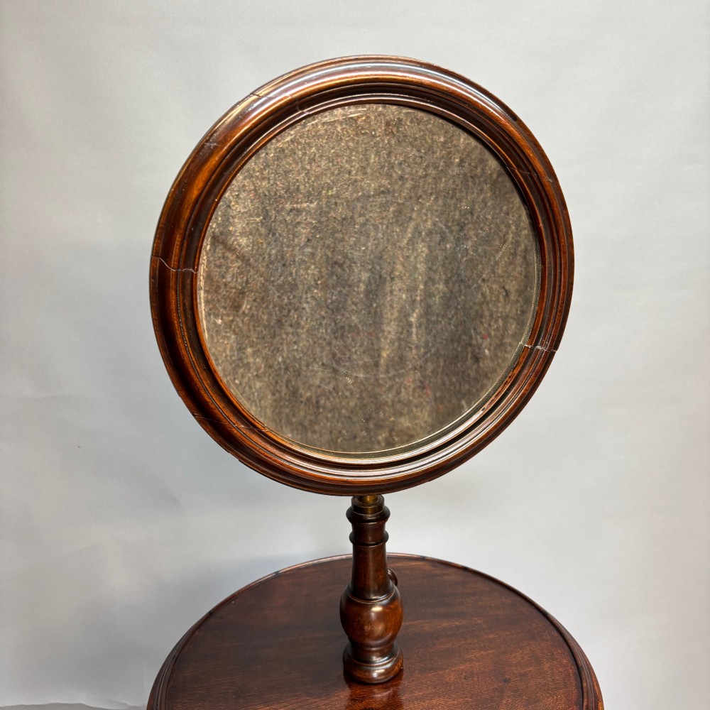 A Victorian dark mahogany shaving stand featuring an adjustable circular mirror, a round tier, a hinged compartment, turned support stem, and tripod cabriole legs. View III