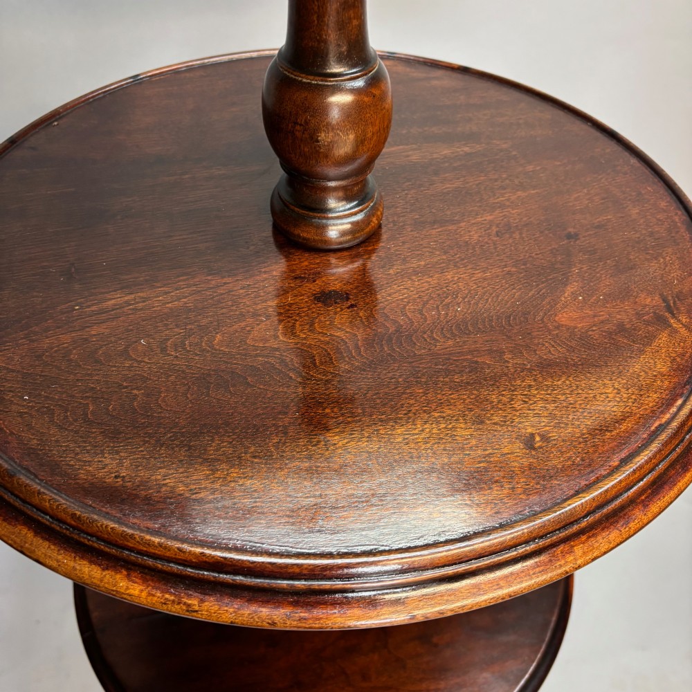 A Victorian dark mahogany shaving stand featuring an adjustable circular mirror, a round tier, a hinged compartment, turned support stem, and tripod cabriole legs. View V