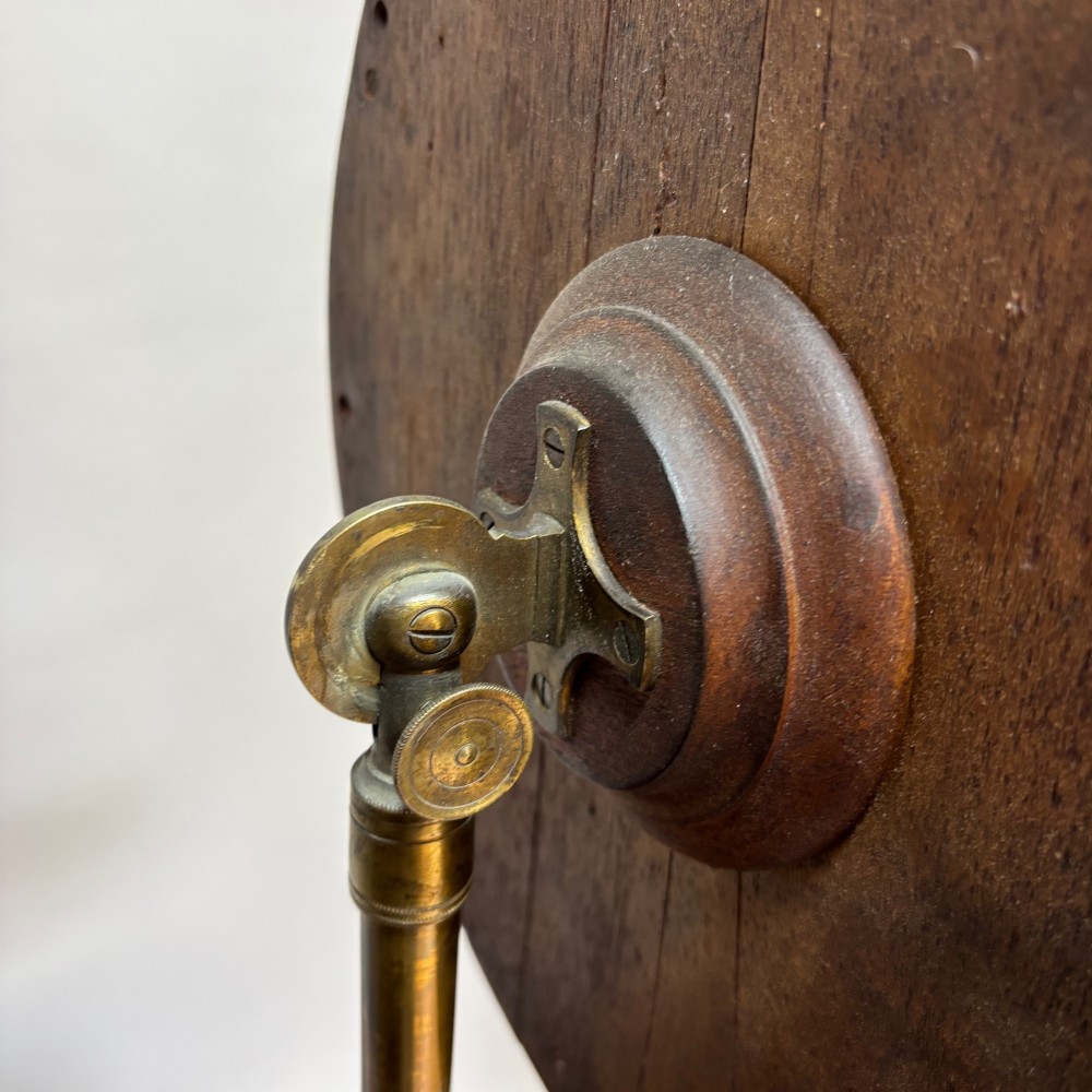 A Victorian dark mahogany shaving stand featuring an adjustable circular mirror, a round tier, a hinged compartment, turned support stem, and tripod cabriole legs. View VI
