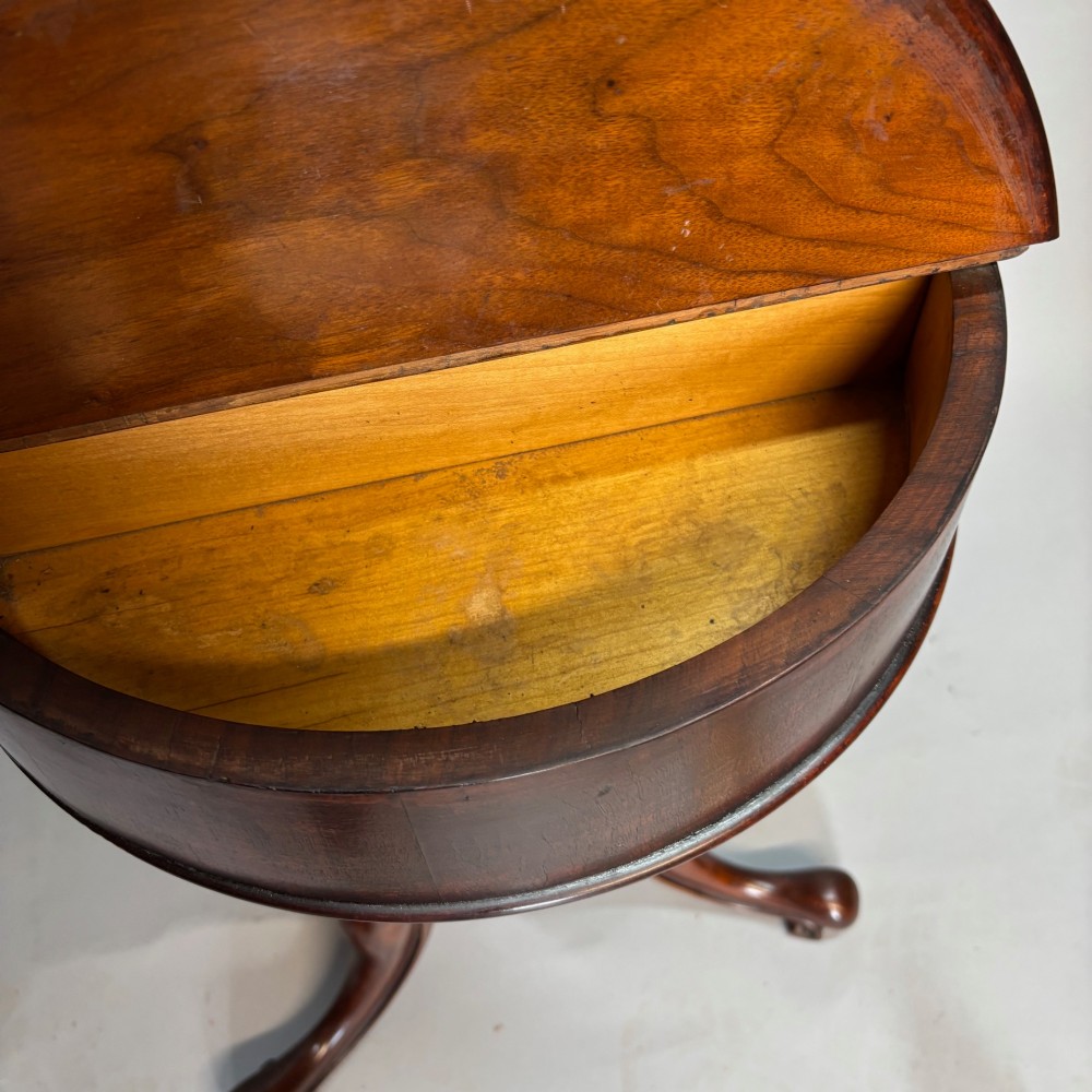 A Victorian dark mahogany shaving stand featuring an adjustable circular mirror, a round tier, a hinged compartment, turned support stem, and tripod cabriole legs. View X
