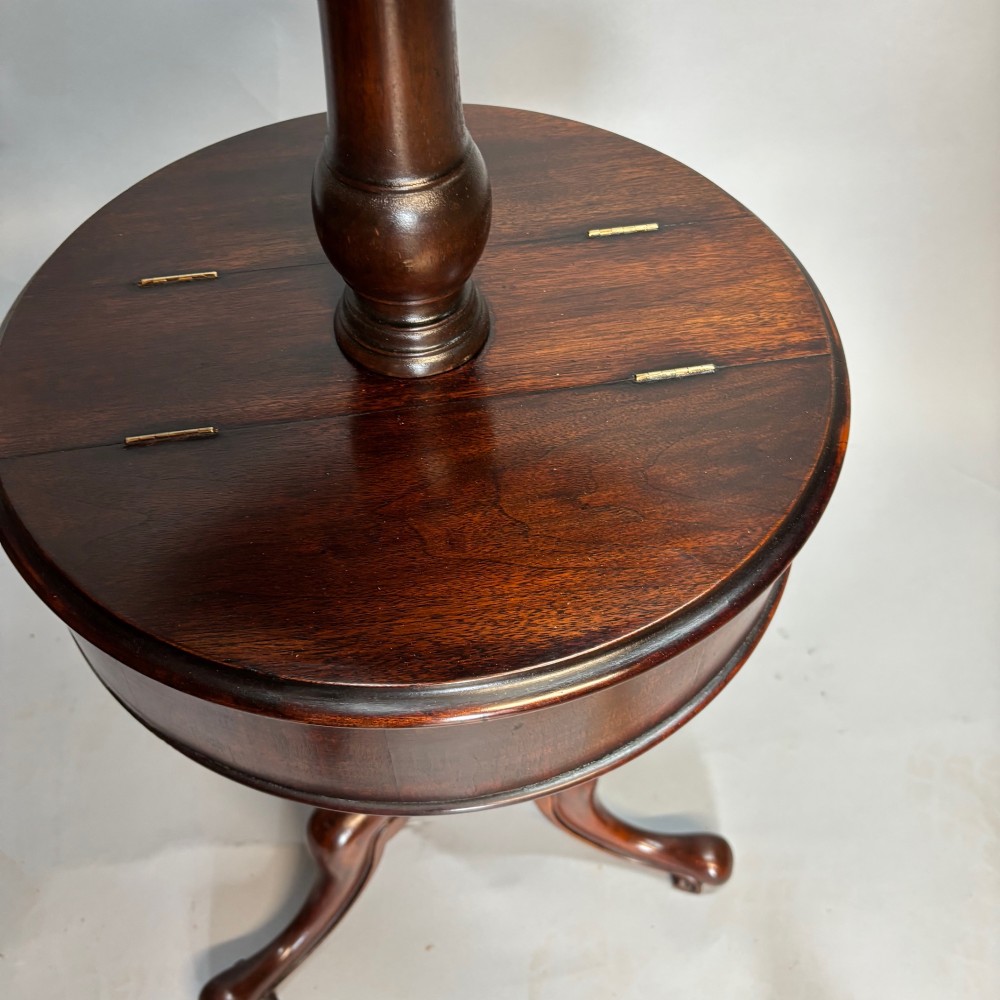 A Victorian dark mahogany shaving stand featuring an adjustable circular mirror, a round tier, a hinged compartment, turned support stem, and tripod cabriole legs. View XI