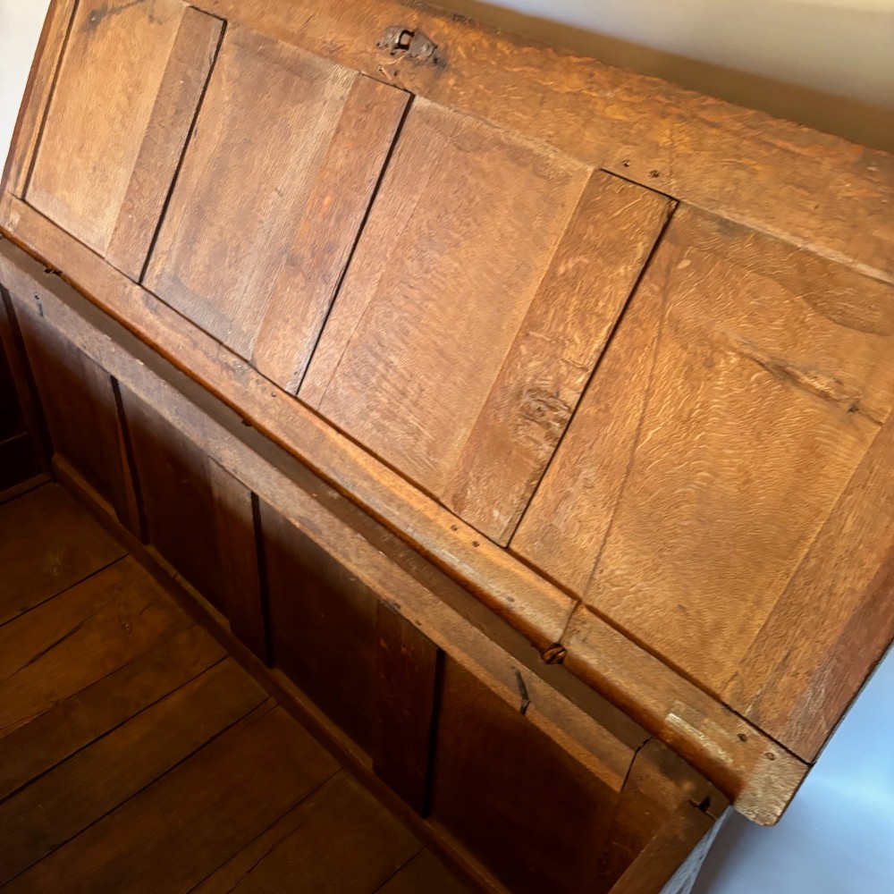 A seventeenth-century dark oak coffer featuring four carved panelled sections with diamond lozenges and decorative carved borders. View III
