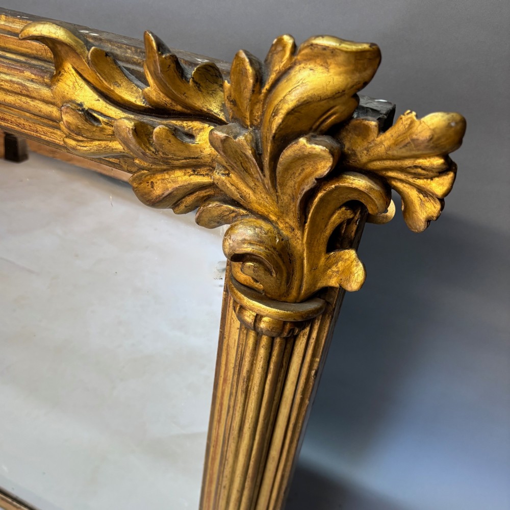 A nineteenth-century rectangular giltwood mirror featuring fluted side columns topped with carved acanthus leaf capitals. View VII