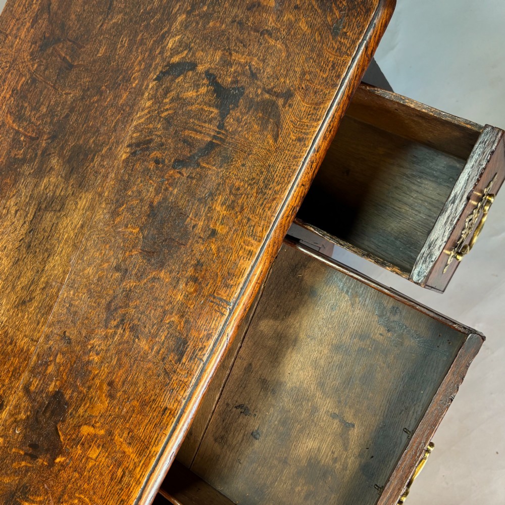 An 18th-century George II oak lowboy featuring three drawers with pierced brass handles, a shaped apron, and four cabriole legs with pad feet. View V